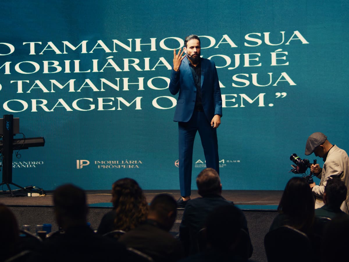 Alessandro Miranda no palco com o telão da imersão